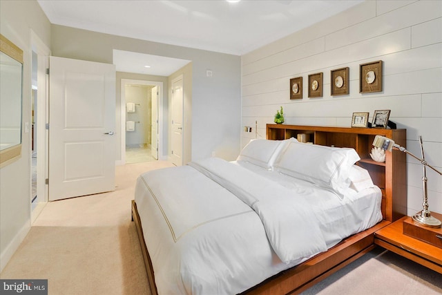 bedroom with connected bathroom, light colored carpet, and ornamental molding