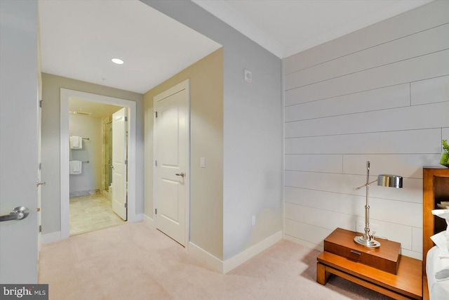 hallway with wooden walls and light colored carpet