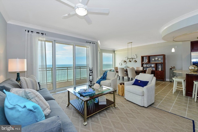 tiled living room with a water view, crown molding, and ceiling fan