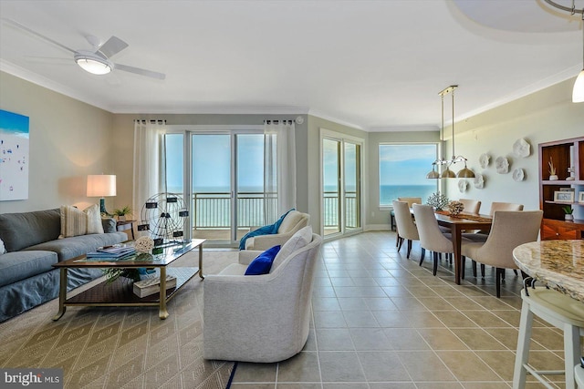 tiled living room with ornamental molding, a water view, and a wealth of natural light