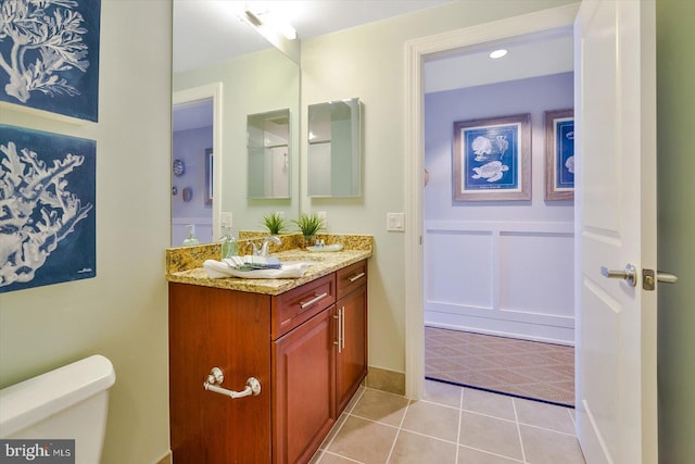 bathroom featuring vanity, tile patterned flooring, and toilet