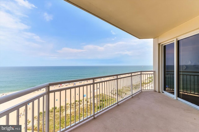 balcony featuring a beach view and a water view