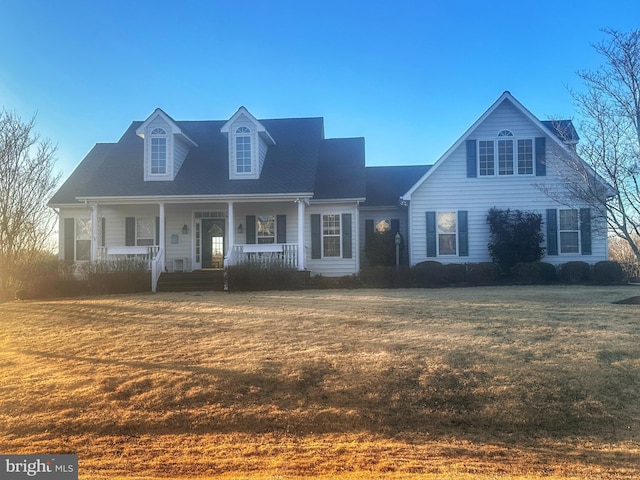 new england style home featuring covered porch and a front lawn