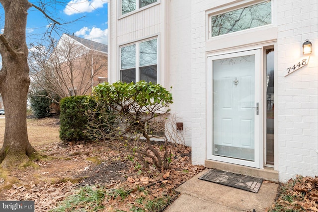 entrance to property featuring brick siding