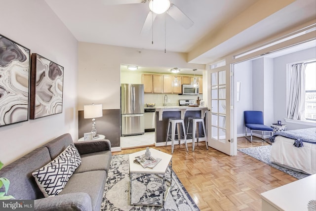 living room with a ceiling fan and baseboards