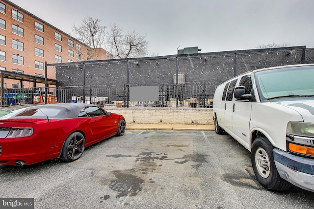 uncovered parking lot featuring fence