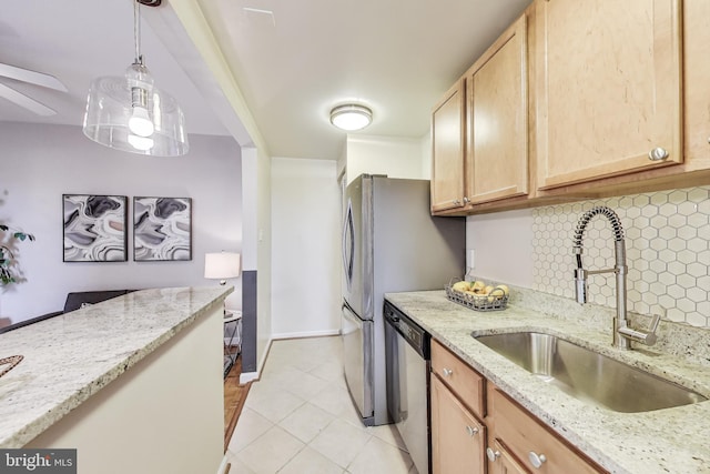 kitchen with dishwasher, hanging light fixtures, a sink, light stone countertops, and backsplash