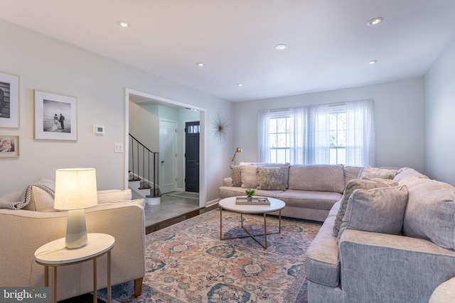 living area featuring baseboards, stairway, and recessed lighting