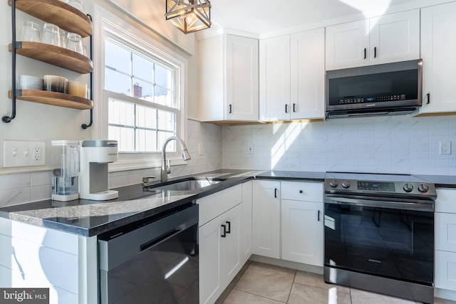 kitchen featuring white cabinets, tasteful backsplash, stainless steel appliances, and a sink