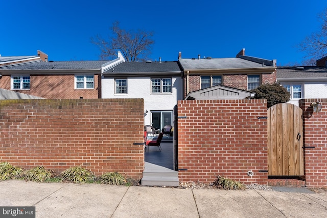 view of front of home with a gate and brick siding