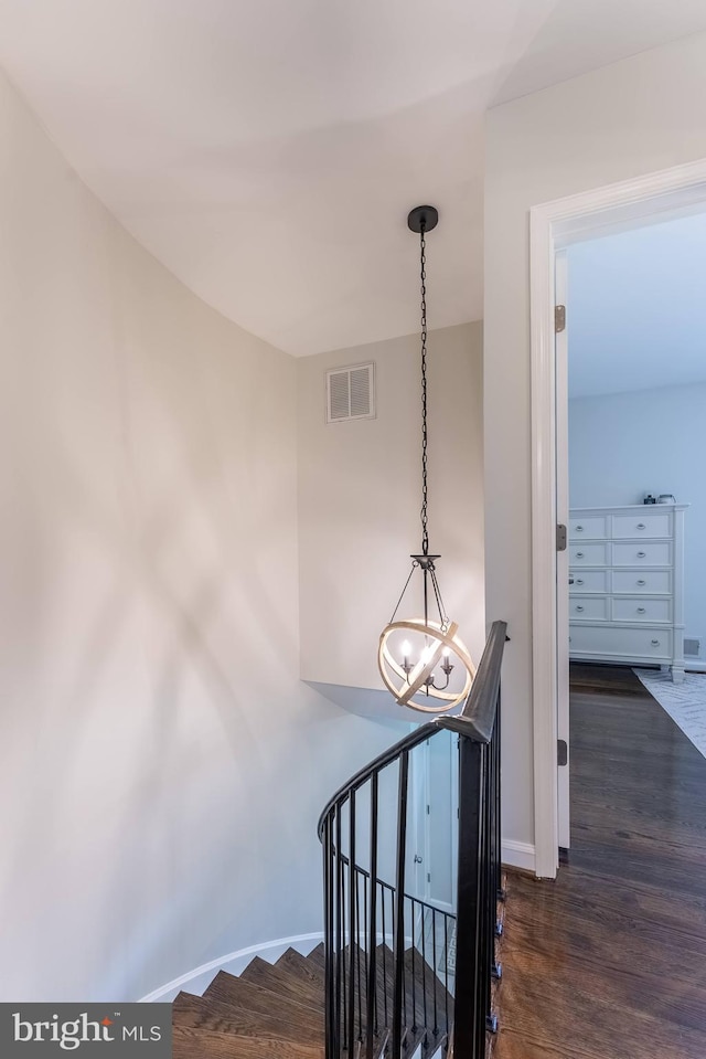 stairway with baseboards, visible vents, a chandelier, and wood finished floors