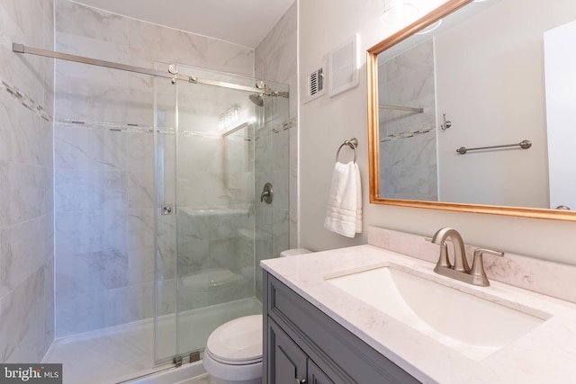 bathroom with a stall shower, visible vents, vanity, and toilet