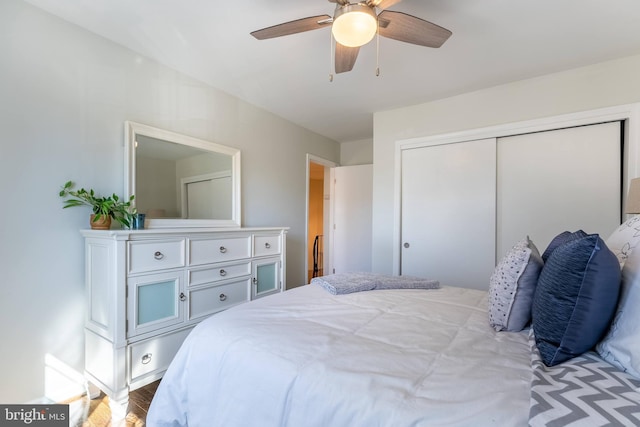 bedroom with a ceiling fan, a closet, and light wood-style flooring