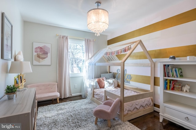 bedroom with a notable chandelier, baseboards, and dark wood-style flooring