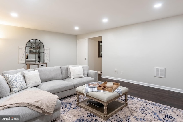 living area featuring dark wood-style floors, recessed lighting, visible vents, and baseboards