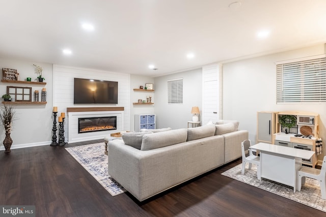 living room with dark wood-type flooring, recessed lighting, a large fireplace, and baseboards