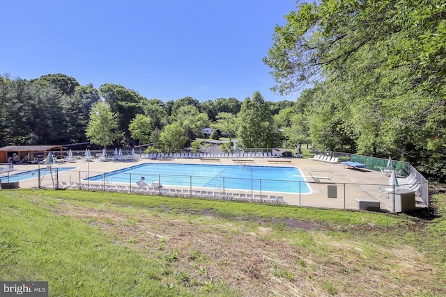 pool featuring fence, a lawn, and a patio