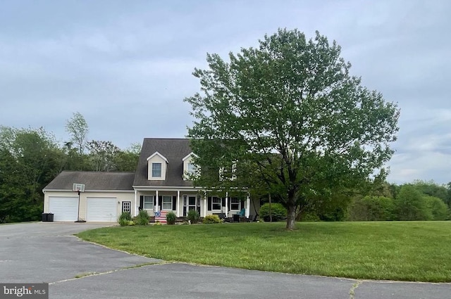 cape cod house featuring an attached garage, aphalt driveway, a porch, and a front lawn