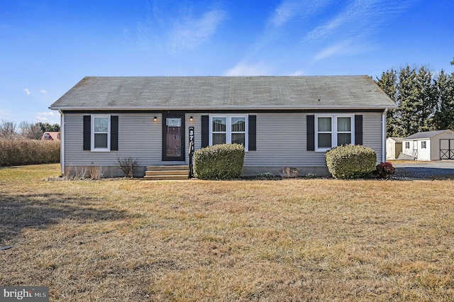 single story home featuring a storage shed and a front yard