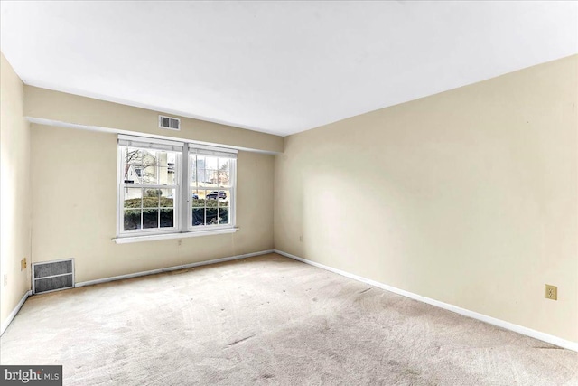 carpeted empty room with visible vents and baseboards