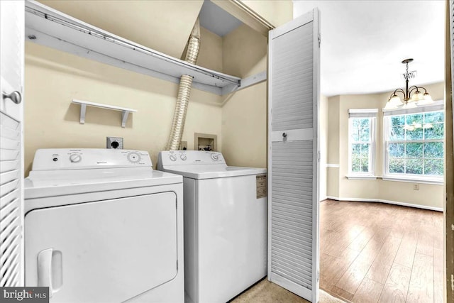 laundry room with laundry area, separate washer and dryer, baseboards, light wood-style floors, and an inviting chandelier