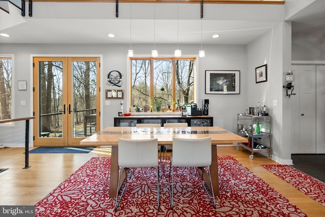 dining space with recessed lighting, french doors, and light wood-type flooring