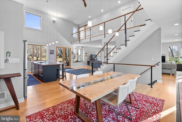 dining space with recessed lighting, stairway, light wood-style flooring, and baseboards