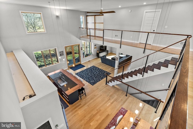 living room featuring a high ceiling, recessed lighting, wood finished floors, and ceiling fan