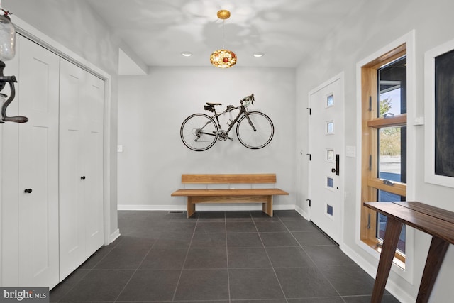 foyer with a chandelier, recessed lighting, baseboards, and dark tile patterned floors