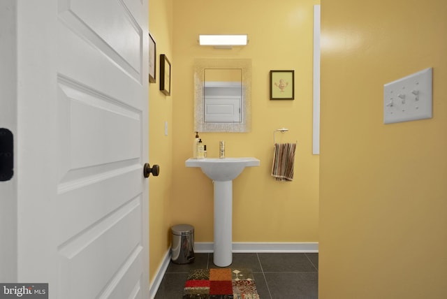 bathroom with baseboards and tile patterned flooring