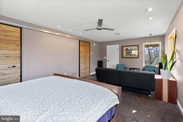 bedroom with recessed lighting, visible vents, a barn door, and dark carpet