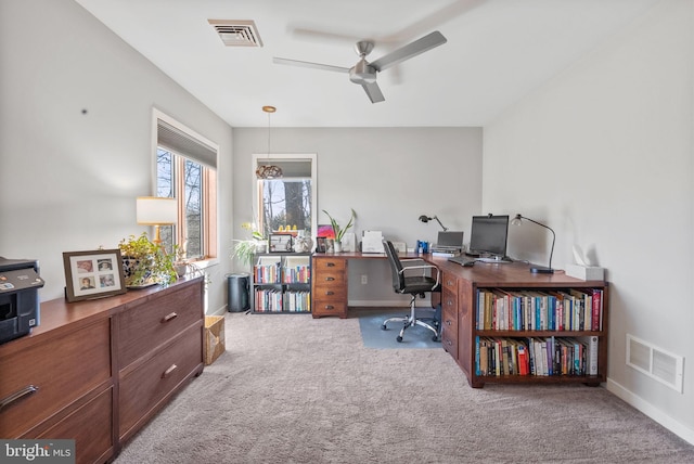 carpeted office featuring visible vents, baseboards, and ceiling fan