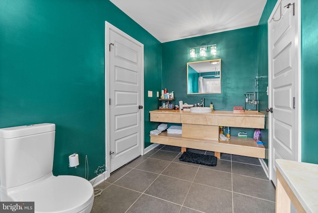 bathroom featuring tile patterned flooring, toilet, vanity, and baseboards