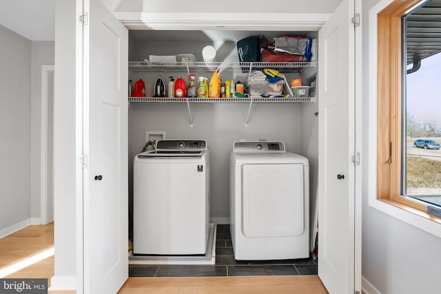 washroom featuring washer and dryer, laundry area, baseboards, and wood tiled floor