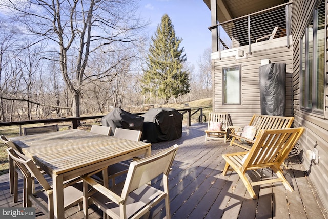 wooden deck with outdoor dining space and grilling area