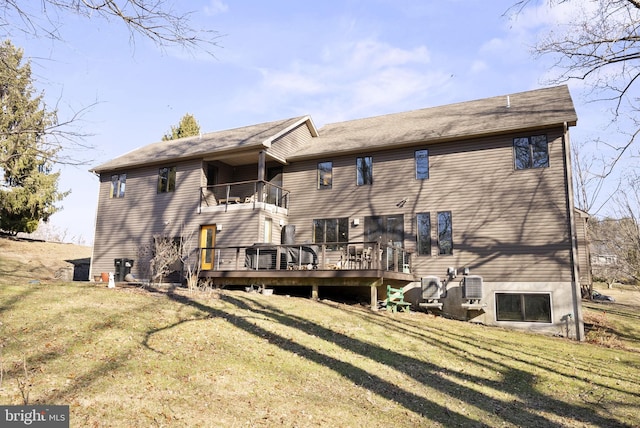 rear view of property featuring a balcony, central AC unit, and a lawn