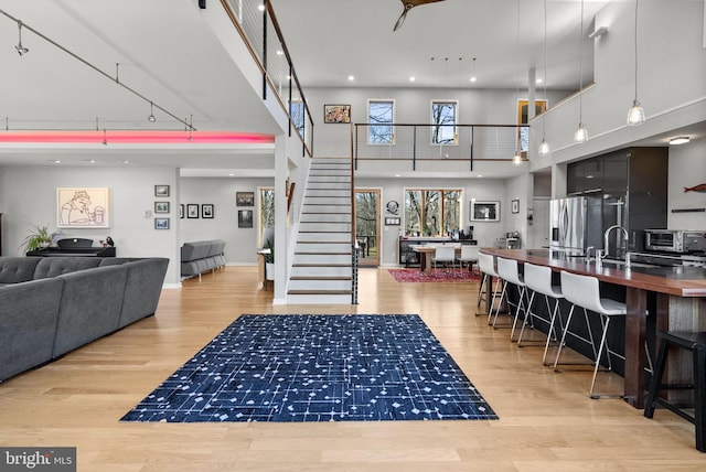 interior space featuring recessed lighting, stairway, a high ceiling, and wood finished floors