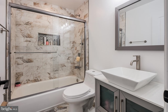 bathroom with combined bath / shower with glass door, toilet, and vanity