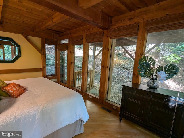 bedroom with light hardwood / wood-style floors, wooden ceiling, access to exterior, and beam ceiling