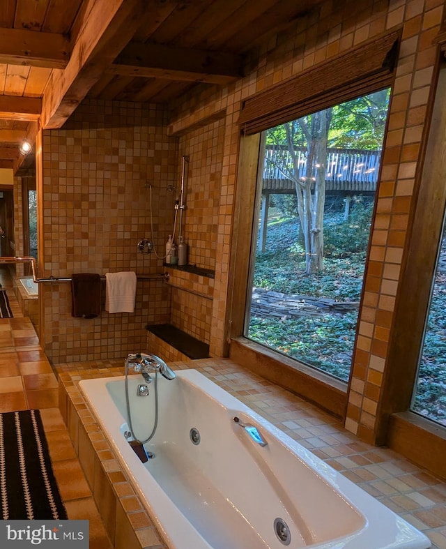 bathroom featuring beamed ceiling, wooden ceiling, and tiled tub