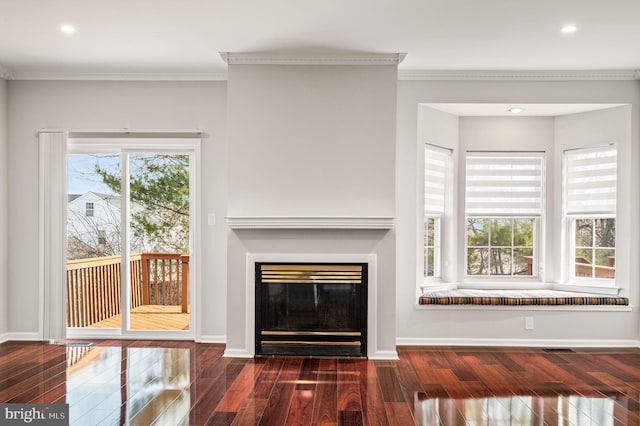 unfurnished living room with ornamental molding, plenty of natural light, and dark hardwood / wood-style floors