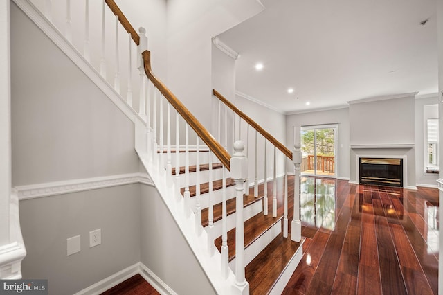 stairs featuring ornamental molding and wood-type flooring