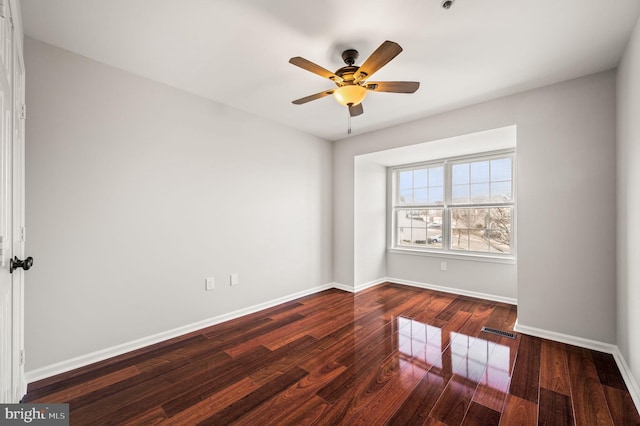 unfurnished room featuring dark wood-type flooring and ceiling fan