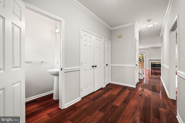 corridor with crown molding and dark wood-type flooring