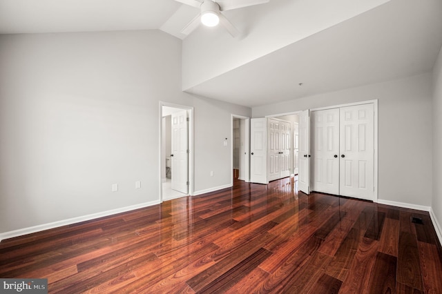 unfurnished bedroom featuring vaulted ceiling, two closets, dark hardwood / wood-style flooring, ceiling fan, and ensuite bath