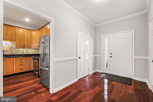 foyer entrance featuring ornamental molding and dark hardwood / wood-style floors