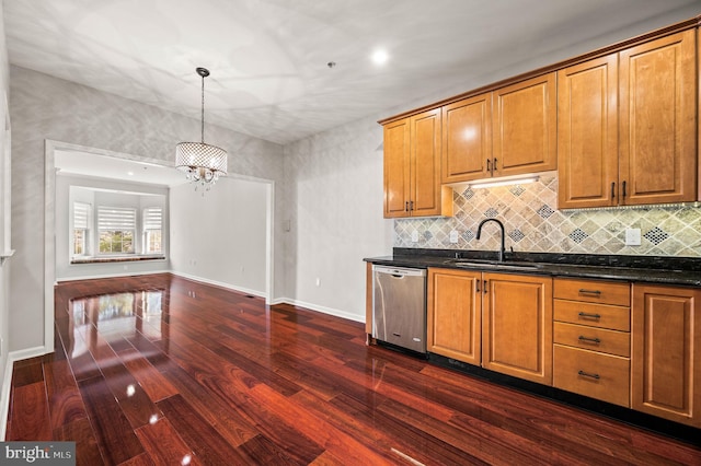 kitchen featuring tasteful backsplash, dishwasher, sink, dark hardwood / wood-style flooring, and hanging light fixtures