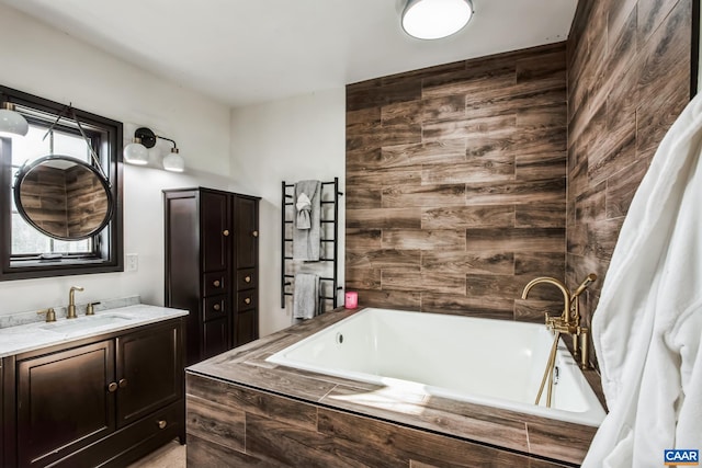 bathroom with vanity and tiled tub