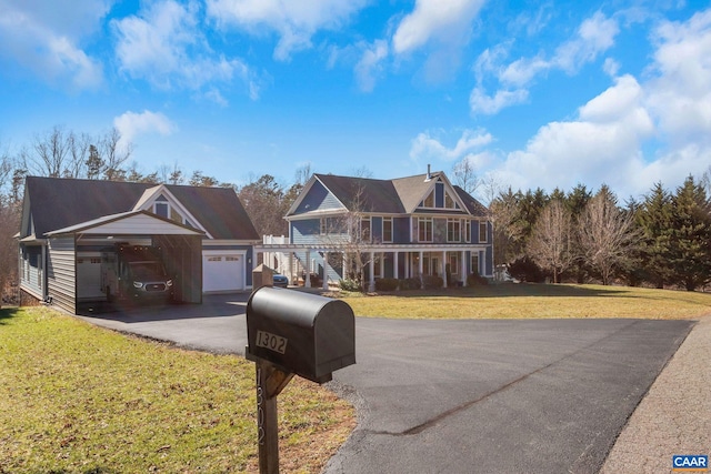 view of front facade with a porch, a garage, an outdoor structure, and a front lawn