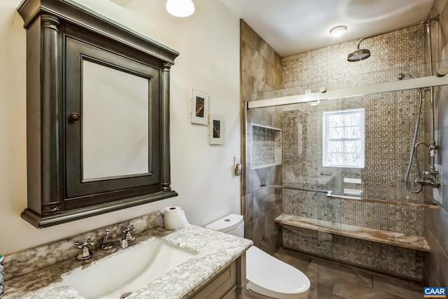 bathroom featuring vanity, tiled shower, and toilet